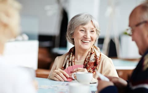 Elderly Woman Playing Cards With Elderly Man