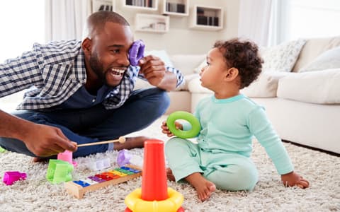 Father Playing With Young Son On Floor