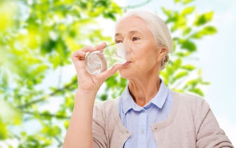 Elderly Woman Drinking Water Outside