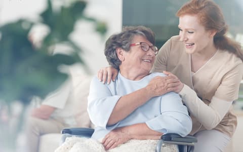 Eldlery Woman In Wheel Chair Smiling At Daughter
