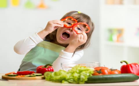 Child Holding Pepper Circles To Her Eyes