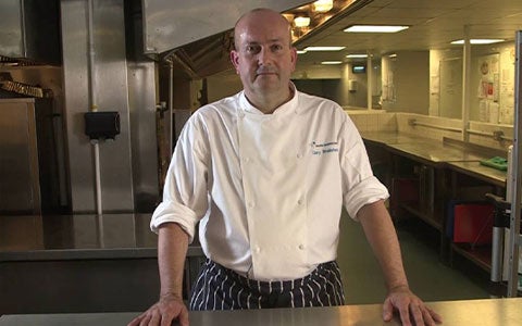 Image Of Chef Standing In Kitchen Looking At Camera