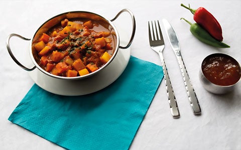 Indian Style Curry In Bowl On Table With Cutlery