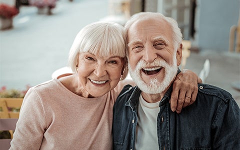 Elderly Couple Sat Together Hugging
