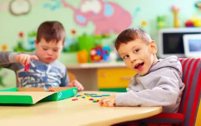 Less Abled Young Boys Plaing At A Table Together