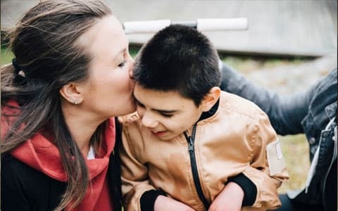 Mother Kissing Less Ables Son On Cheek